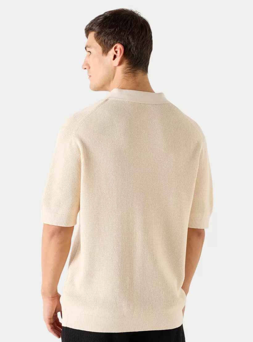 Vista traseira da camiseta polo masculina bege mostrando o caimento regular