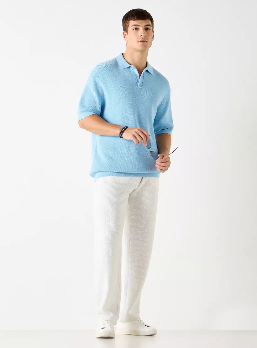 Homem vestindo a camiseta polo masculina azul claro texturizada em look casual