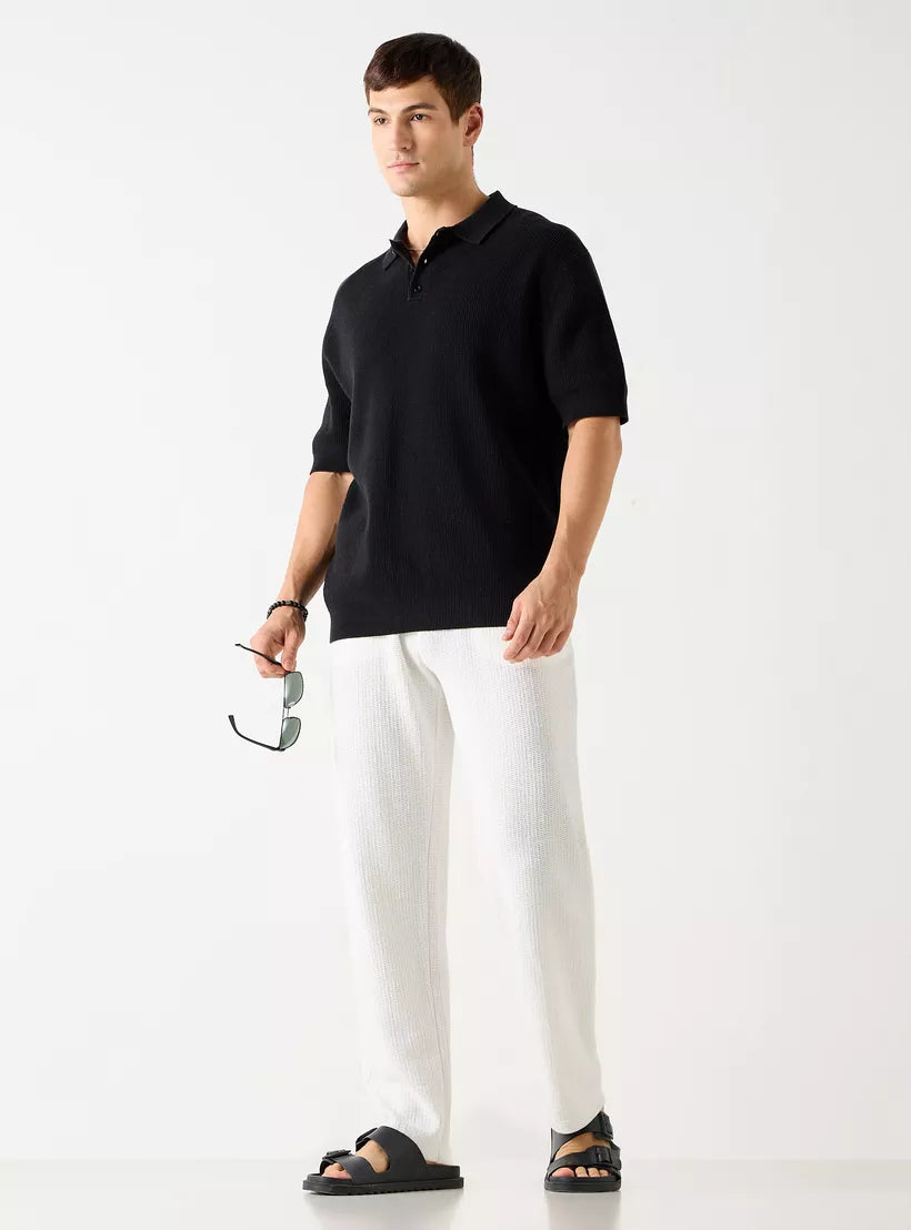 Homem vestindo a camiseta polo masculina preta texturizada em look casual elegante