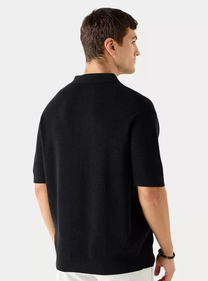 Vista traseira da camiseta polo masculina preta mostrando o caimento regular
